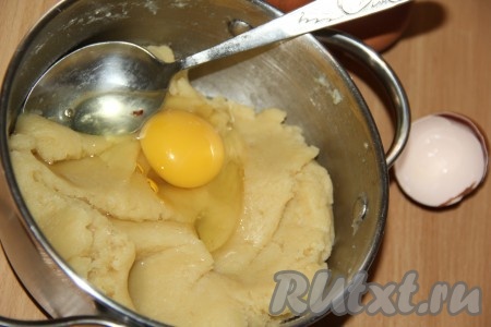Оставить тесто в кастрюле на 5-7 минут. Затем начинаем вводить яйца. Яйца добавляем по одному и после каждого введения тщательно перемешиваем до однородности. Сначала заварное тесто будет комкаться и сопротивляться соединиться с яйцом, а потом начнёт вымешиваться и станет однородным, нежным, вязким.