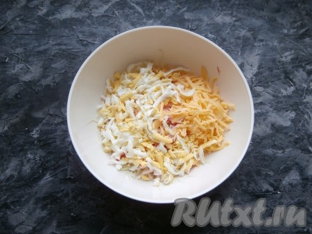 Яйцо и сыр натереть на крупной тёрке, выложить в салат из крабовых палочек и свежей капусты.
