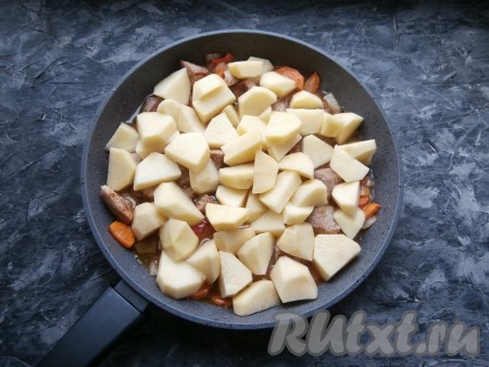 Перемешать, выложить сверху картофель, нарезанный крупными кусками. Влить горячую воду.

