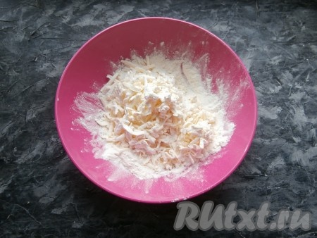 Муку просеять в миску, добавить щепотку соли и натёртое на крупной тёрке холодное масло (или маргарин).