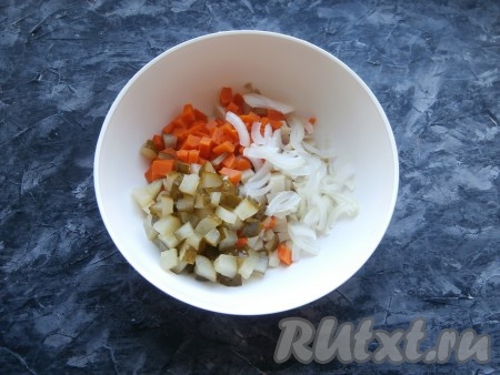 Солёный огурец тоже нарезать средними кубиками. Очищенную луковицу нарезать тонкими перьями. Нарезанные лук и огурчик выложить в салат из картофеля и моркови.
