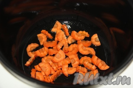 В чашу мультиварки влить растительное масло, выложить очищенную и нарезанную морковь (я нарезала полукольцами). 
