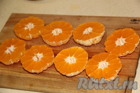 Мандарины почистить. Каждый мандарин разрезать поперёк на две половины. Для этого пирога желательно выбирать мандарины без косточек, если всё же косточки есть, то их нужно удалить.
