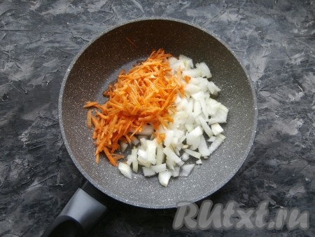 Очищенную луковицу нарезать средними кусочками, очищенную морковку натереть на крупной тёрке, поместить овощи в сковороду, влить растительное масло.