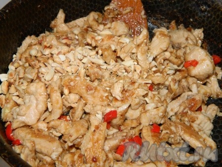 Добавляем порезанный арахис к курице, все хорошо перемешиваем и жарим до готовности.
