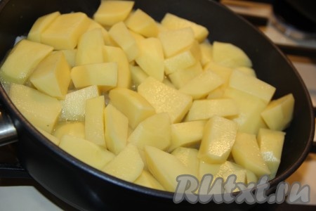Картофель нарезать средними дольками и добавить в сковороду к луку. 