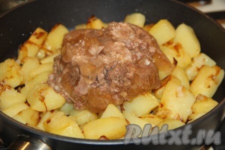 К готовой жареной картошке добавить тушёнку, посолить по вкусу.
