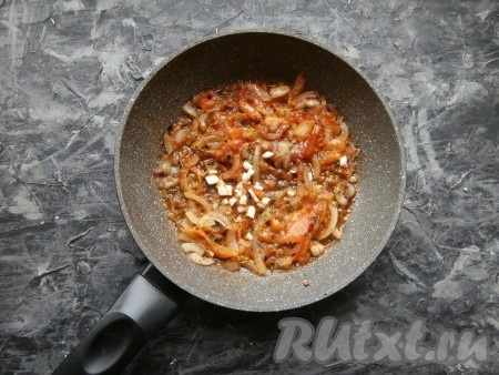 Заранее залить помидоры кипятком на 3-4 минуты, а затем аккуратно удалить кожицу с томатов. В сковороде на среднем огне на оливковом масле обжарить в течение 3-4 минут очищенный и нарезанный тонкими четвертинами лук. Затем добавить очищенные от кожицы и нарезанные тонкими полукружками помидоры, всыпать соль, паприку, чёрный молотый перец, сахар, сушёные базилик, петрушку и орегано, перемешать и протушить на медленном огне несколько минут, иногда помешивая, после чего добавить мелко нарезанный чеснок, перемешать.
