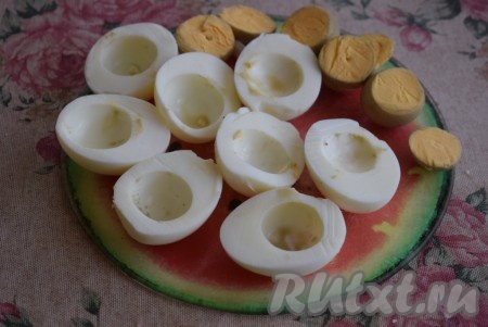 Разрезать каждое яйцо вдоль напополам. Аккуратно извлечь желтки из каждой половинки яйца.
