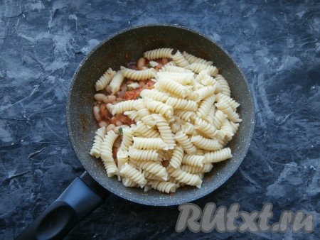 Теперь в сковороду с фасолью в томатном соусе добавить отваренные макароны, тщательно перемешать.
