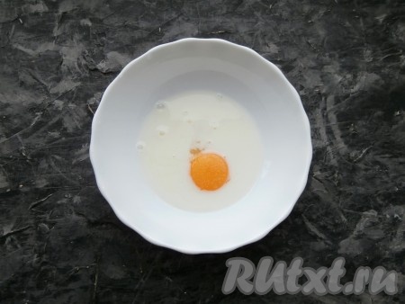Молоко налить в глубокую миску, добавить сырое яйцо и соль.