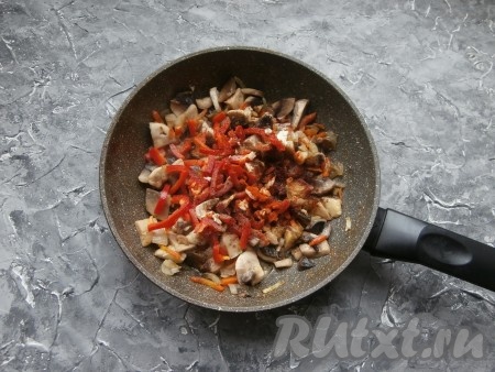 Обжарить, помешивая, пока грибы не уменьшатся в размере (на это потребуется, примерно, минут 5), посыпать специями, паприкой, добавить мелко нарезанный чеснок и, по желанию, нарезанный соломкой болгарский перец.
