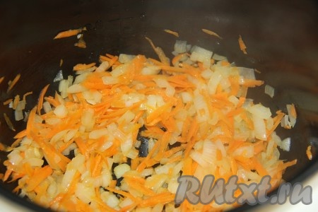 Морковь почистить и натереть на тёрке. Добавить морковь в чашу и обжарить с луком, помешивая, в течение 10 минут.
