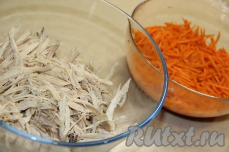 Соединить в миске капусту и куриное филе. Морковь по-корейски отжать от лишнего маринада. Если полоски морковки слишком длинные, разрежьте их на несколько частей. 