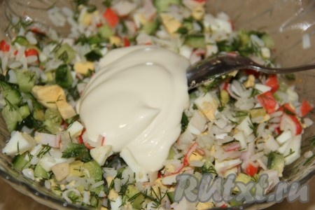 Сюда же выложить отваренный рис, вымытый и мелко нарезанный укроп, перемешать салат, заправить его майонезом, если понадобится, подсолить по вкусу.