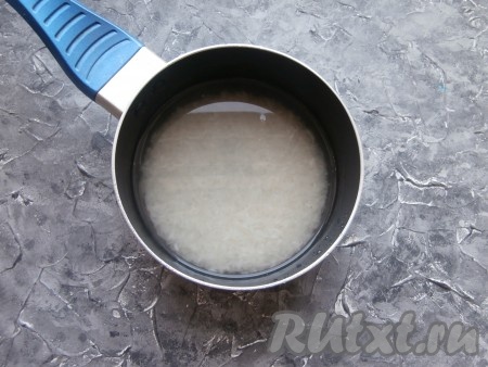 Залить рис 1,5 стаканами холодной воды, поставить на огонь.
