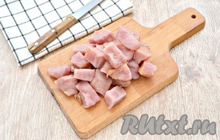 Свинину промыть, обсушить, нарезать на средние кусочки и выложить к обжаренным овощам.
