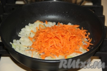 К обжаренному луку выложить предварительно очищенную и натёртую на крупной тёрке морковку.
