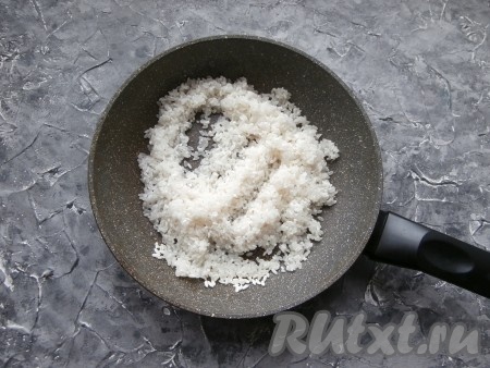 Влить в сковороду 1 столовую ложку растительного масла, разогреть, выложить рис и прогреть его, перемешивая, минуты 3-4.
