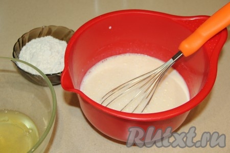 Затем в желтково-сахарную смесь влить молоко и ещё раз перемешать венчиком.
