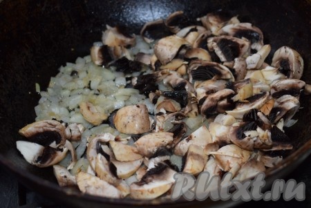 В сковороде разогреем растительное масло, выложим в сковороду измельчённый лук и обжарим его на среднем огне, помешивая, до прозрачности. Затем добавим нарезанные шампиньоны и обжарим грибы с луком в течение 8-9 минут. Посолим, поперчим, добавим специи по вкусу.
