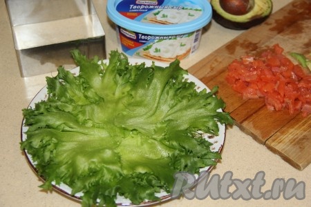 Листья салата вымыть, а затем обсушить и выложить на плоскую тарелку. Филе красной рыбы нарезать на мелкие кубики.
