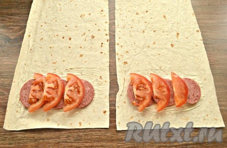 На колбасу разложить нарезанный полукольцами помидор.