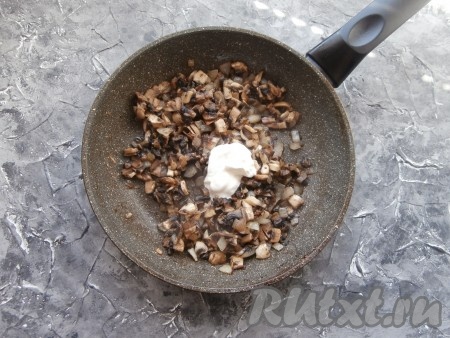 Обжарить грибы на среднем огне до испарения жидкости (5-7 минут), затем добавить 1 столовую ложку сметаны, перемешать.
