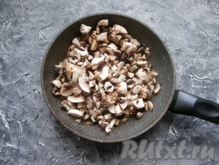 Шампиньоны мелко нарезать, выложить в сковороду с растительным маслом. Обжарить грибы на среднем огне до полного испарения жидкости из шампиньонов (в течение минут 5-7), не забывая периодически помешивать. Обжаренные шампиньоны остудить.