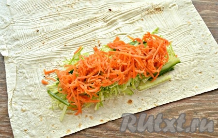 Поверх огурчиков выложить морковку по-корейски (если полоски корейской моркови очень длинные, их желательно предварительно разрезать на несколько частей).