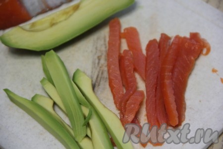 Филе слабосолёной красной рыбы (у меня лосось) нарезать на длинные бруски. Авокадо почистить от шкурки, удалить косточку и нарезать мякоть на длинные брусочки, как рыбу.
