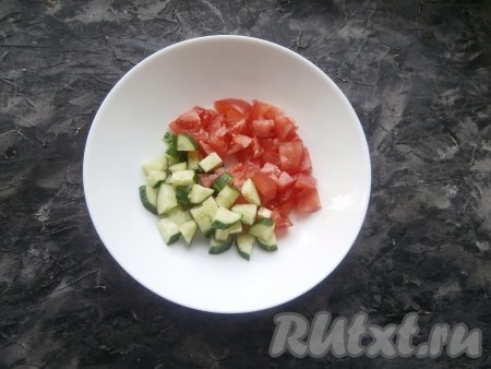Огурцы и помидоры помыть, нарезать средними кубиками, выложить в салатник.