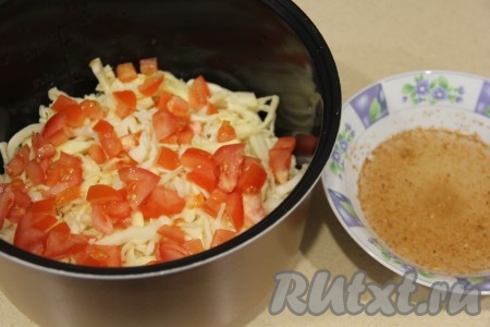 Поверх капусты выложить мелко нарезанный помидор. В отдельную посуду влить 1 мультистакан воды комнатной температуры, добавить соль и специи, хорошо перемешать.