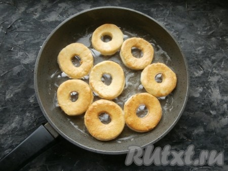 Жарить пончики на среднем огне до румяности с одной стороны, далее перевернуть и жарить их ещё 2-3 минуты.