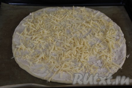 Сыр натереть на тёрке. Выложить на каждую заготовку пиццы 1/4 часть натёртого сыра.