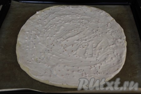Для приготовления соуса для пиццы нужно соединить сметану, майонез, горчицу и чеснок, пропущенный через пресс, влить соевый соус и тщательно перемешать. На присыпанной мукой поверхности каждую из двух частей теста раскатать в круг диаметром 28 см и переложить на противень, застеленный пергаментом (или тефлоновым ковриком). 1/4 часть соуса отложить (он нам понадобится позже), а оставшимся соусом смазать всю поверхность заготовок.
