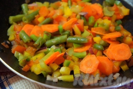 Добавить в суп с красной чечевицей обжаренные овощи, перемешать, довести до кипения, убавить огонь до минимума и варить ещё 10 минут.
