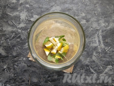 Лимон тщательно вымыть. 1/4 часть лимона нарезать на части и вместе с листочками свежей мяты поместить на дно литровой банки.