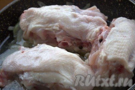 Куриные спинки (или любые другие порционные части курицы) промыть водой и выложить к обжаренному луку, влить воду, добавить чёрный перец горошком.