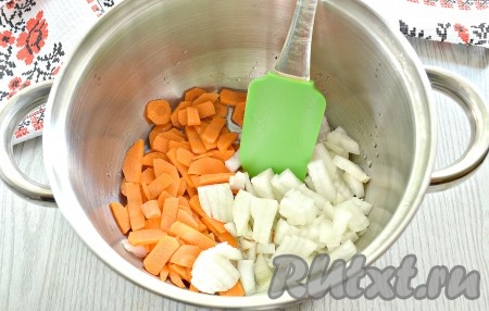 Очищаем морковку и репчатый лук. Морковь нарезаем небольшими тонкими брусочками. Репчатый лук нарезаем кусочками. В подходящей кастрюле (или сковороде с высокими бортами) прогреваем растительное масло. Выкладываем нарезанные морковку и лук, обжариваем их на умеренном огне 2-3 минуты, иногда перемешивая.