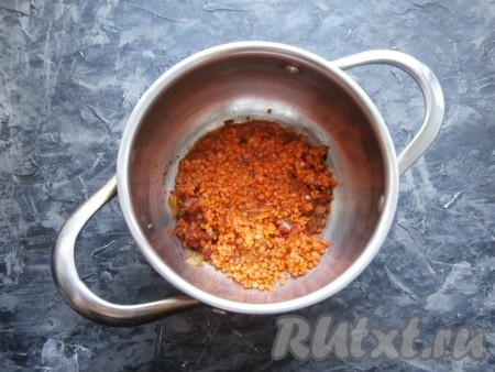 Всыпать 1 чайную ложку муки, перемешать и обжарить 1-2 минуты, помешивая, затем добавить красную чечевицу.