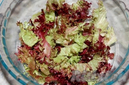 Взять форму и укладывать слоями салат. Сначала уложить половину листового салата.