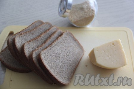 Подготовить продукты для приготовления сухариков с сыром в духовке. Нарезать хлеб на ломтики.