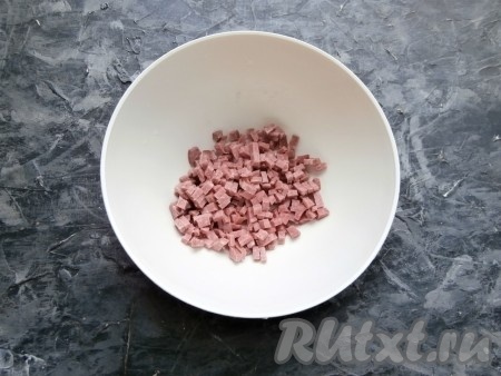 Колбасу нарезать маленькими кубиками в отдельную миску. Для закуски подойдёт копчёная, полукопчёная или варёная колбаса.