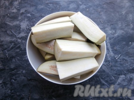 Баклажаны помыть, разрезать каждый на 6-8 частей-брусков. Морковь и зубчики чеснока очистить, удалить семена с плодоножкой из болгарского перца.