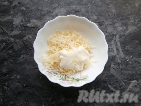 Сыр натереть на средней терке в отдельную миску, добавить измельчённый чеснок и майонез.