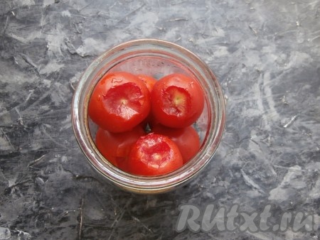 Плотно выложить помидоры в чистую литровую банку ямочками кверху.
