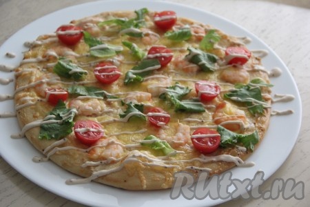 Нанести решётку из соуса и посыпать натёртым сыром. Аналогично сформировать и испечь вторую пиццу.