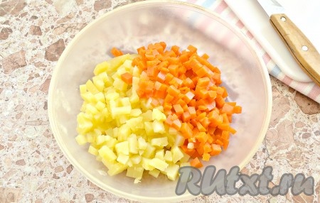 Заранее для салата отвариваем в кожуре картофель и морковь (на варку обычно требуется 20-25 минут, полностью готовые овощи должны легко прокалываться вилкой), корнеплоды остужаем и затем очищаем. Отвариваем куриные яйца вкрутую (варим 8-10 минут с начала закипания воды), остужаем их и очищаем. Ветчину выбирайте на свой вкус. Вместо укропа можно взять зелёный лук. Морковь и картофель нарезаем на мелкие кубики, выкладываем в достаточно объёмную миску. Нарезая ингредиенты для салата "Оливье", стараемся, чтобы все кубики были, примерно, одинакового размера.