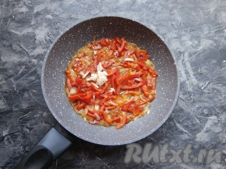 Потушить болгарский перец с луком на среднем огне, иногда перемешивая овощи, минуты 3-4, затем добавить измельчённый чеснок, перемешать и потомить ещё 2-3 минуты.